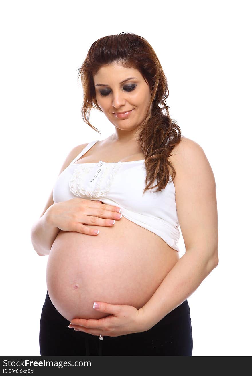 Pregnant woman holding her bare belly isolated on white