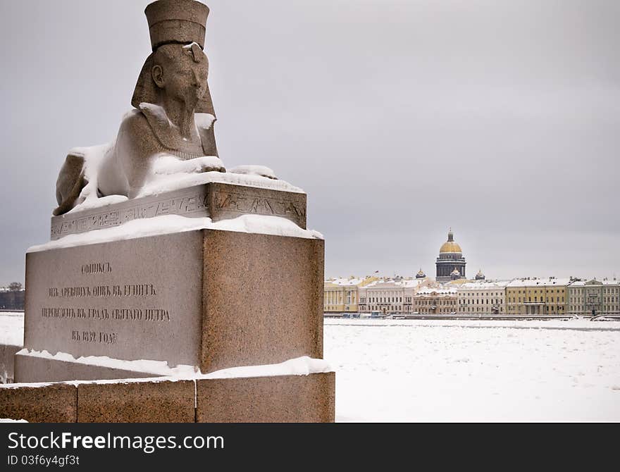 Egyptiac sphinx on the background of St. Isaac's Cathedral in winter. Egyptiac sphinx on the background of St. Isaac's Cathedral in winter