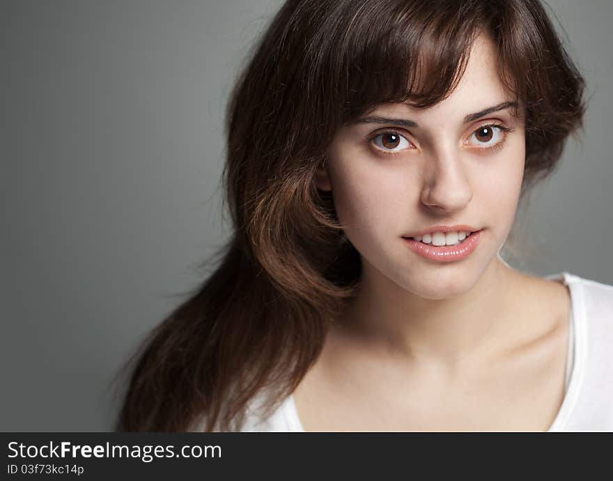 Close up portrait smiling girl on a grey background