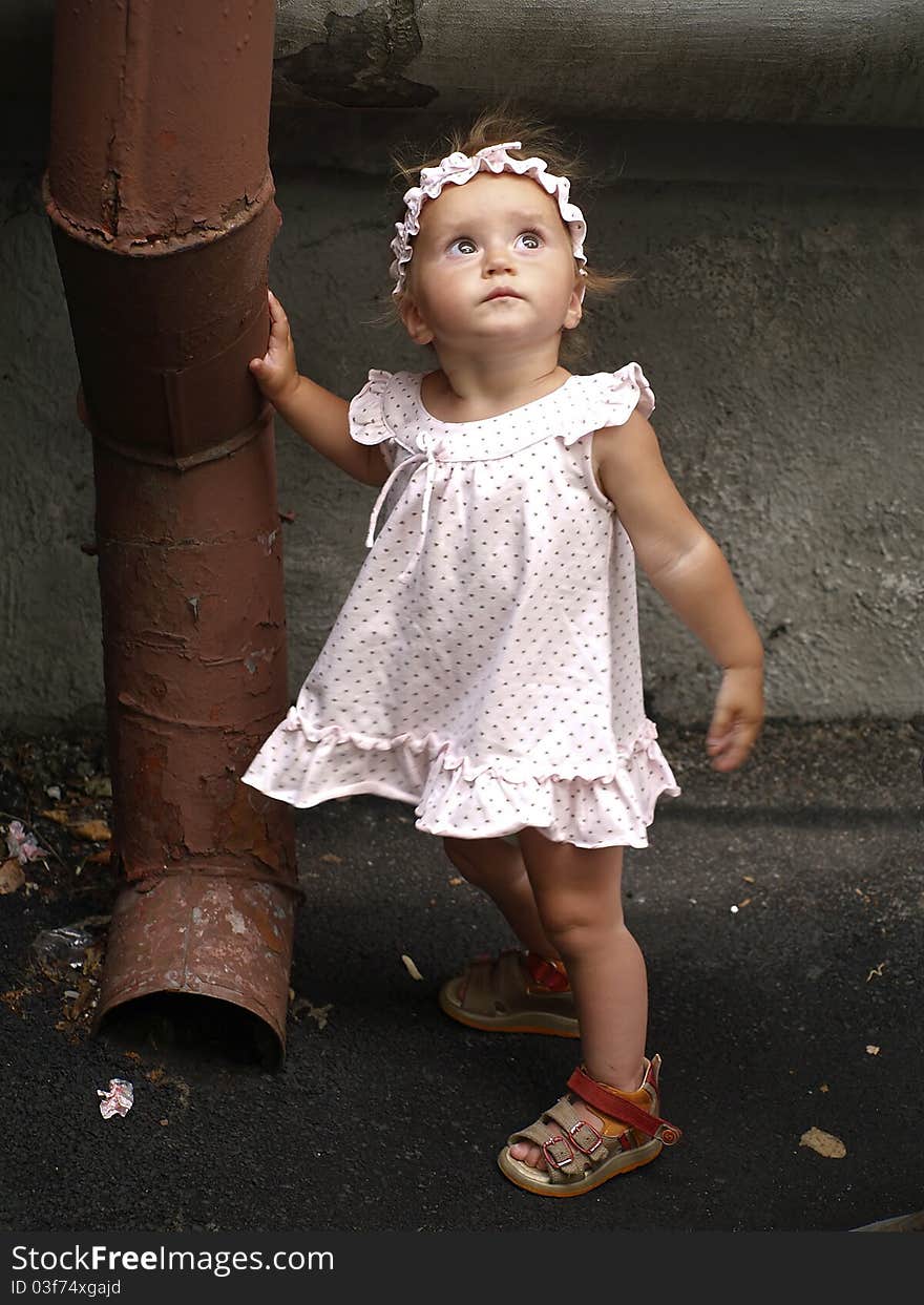 Toddler girl and rainwater pipe