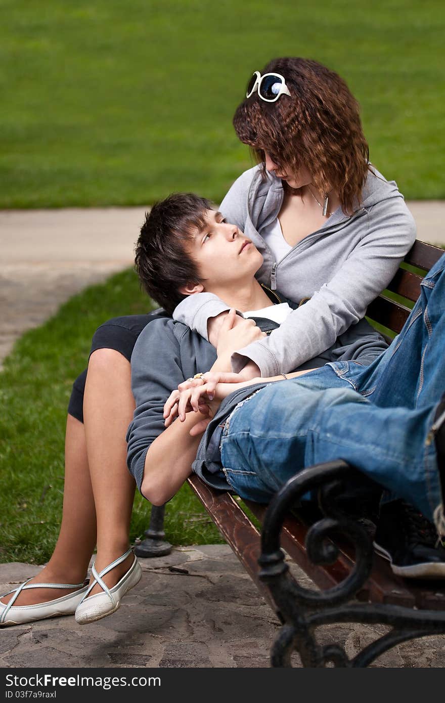 Attractive couple sitting on bench in the park