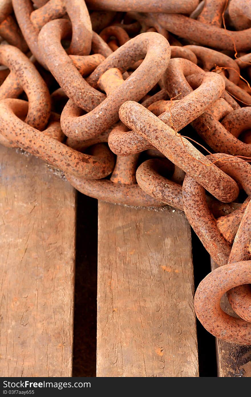 Old rusty chain on wooden background