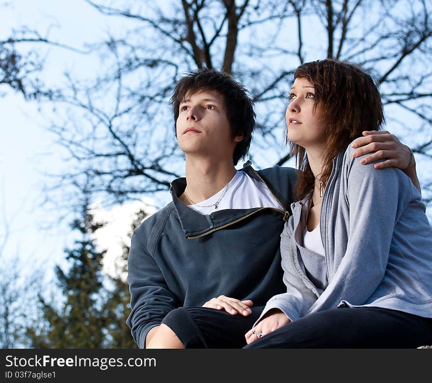 Young couple in the park, blue sky in background