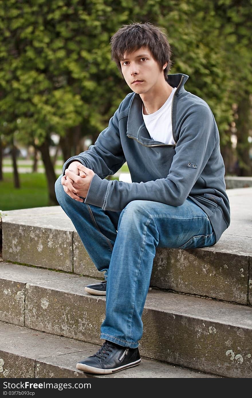 Young man sitting on stairs, outdoor