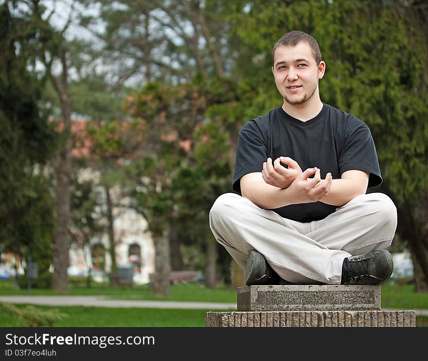 Young man doing yoga at the park