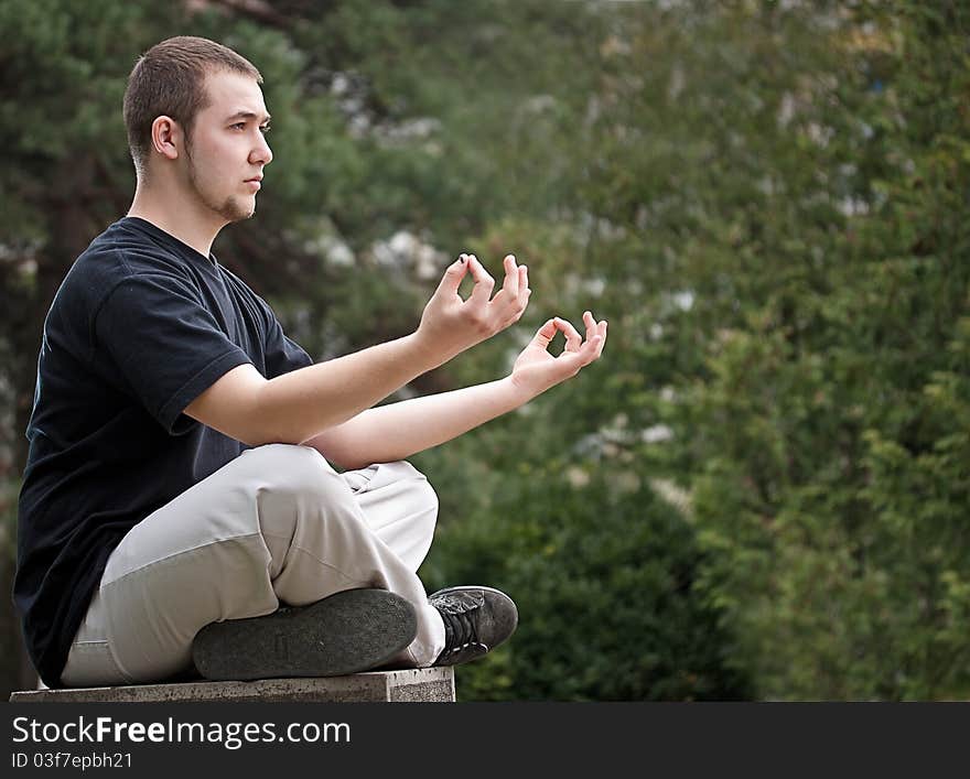 Young man doing yoga at the park