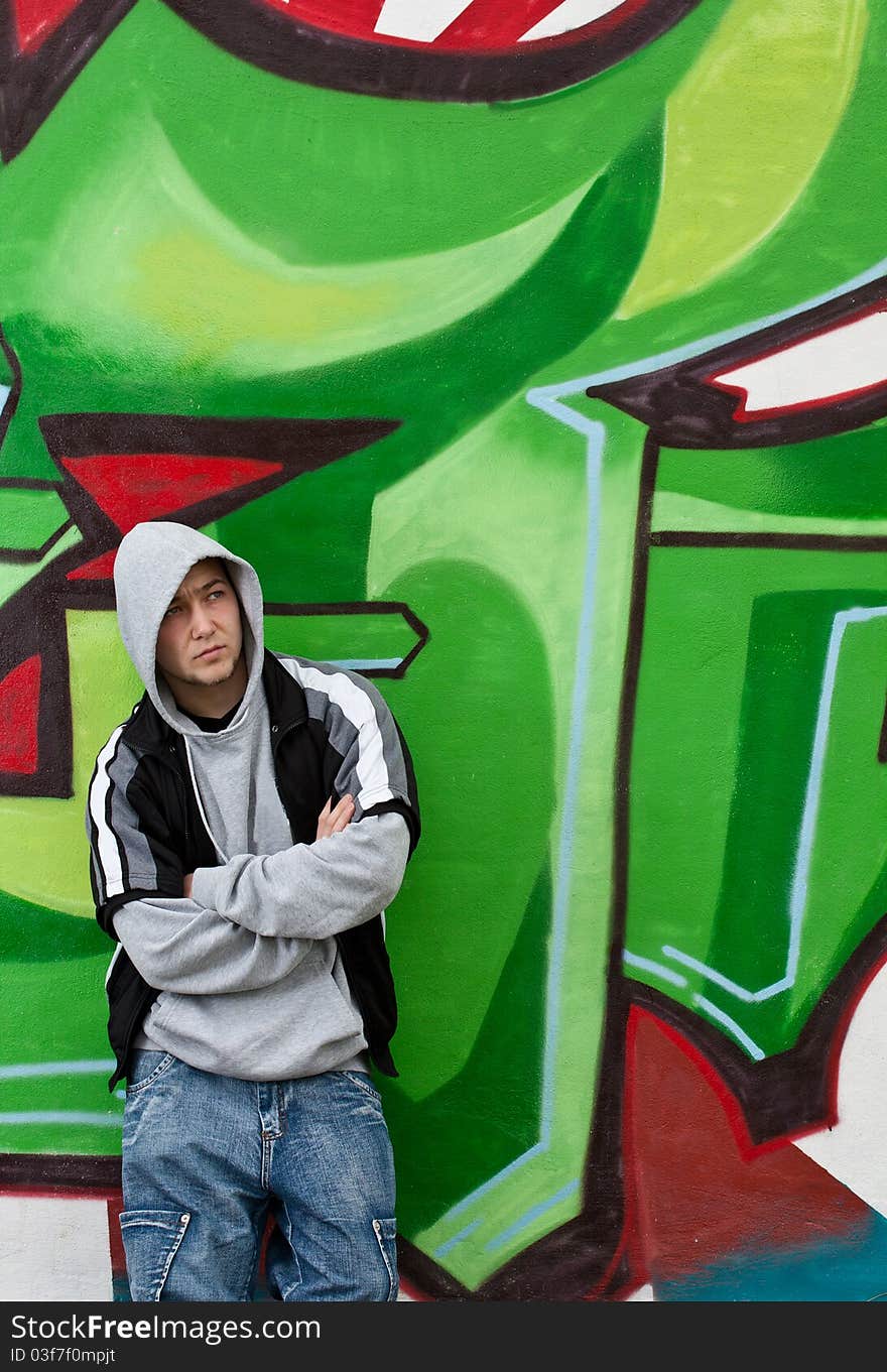 Man leaning against wall with graffiti