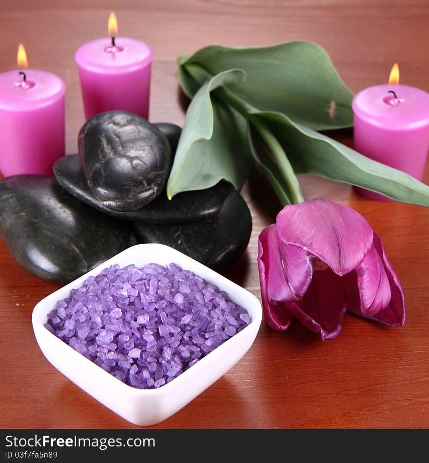 Lavender spa salt, spa stones, candles and a tulip flower. Lavender spa salt, spa stones, candles and a tulip flower