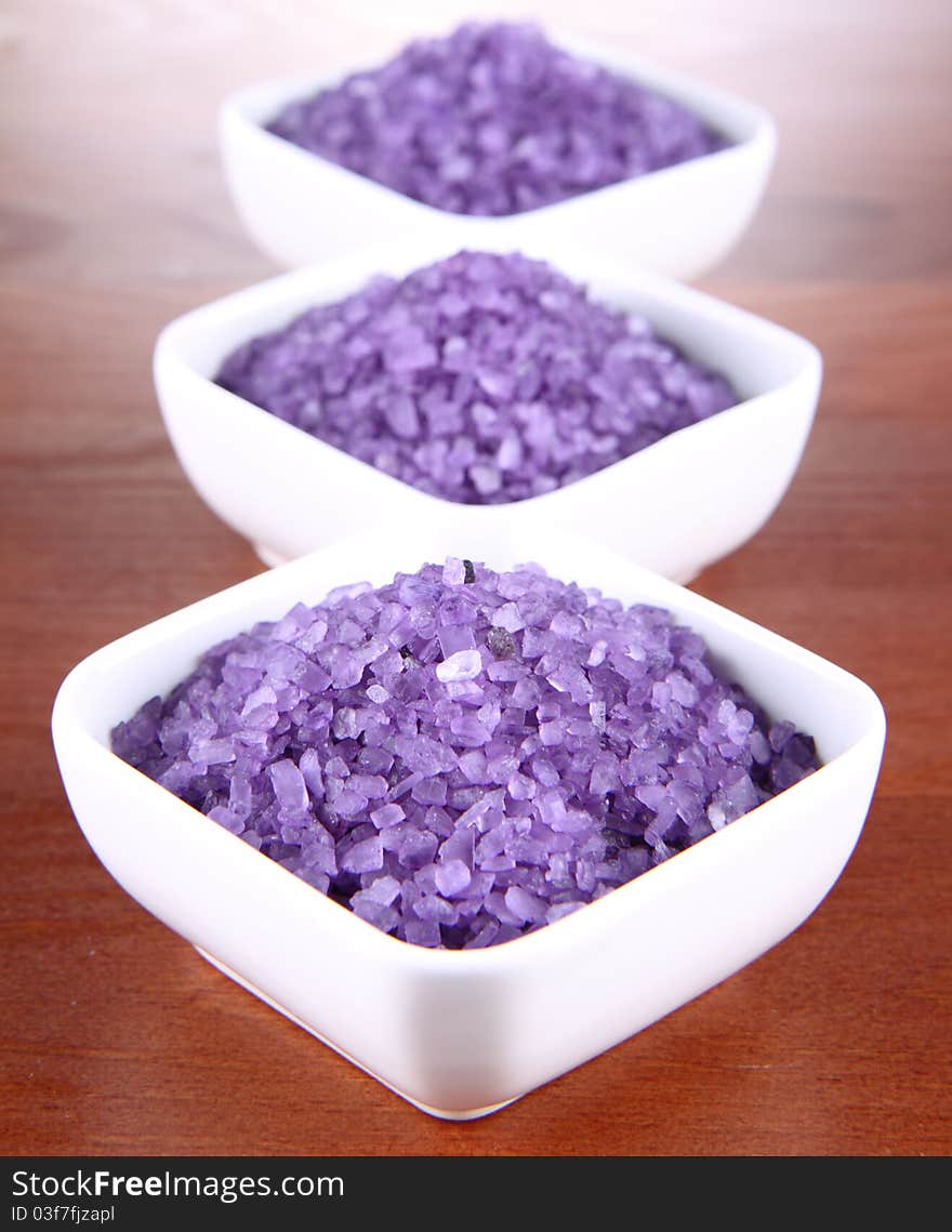 Lavender spa salt in white bowls on a wooden background