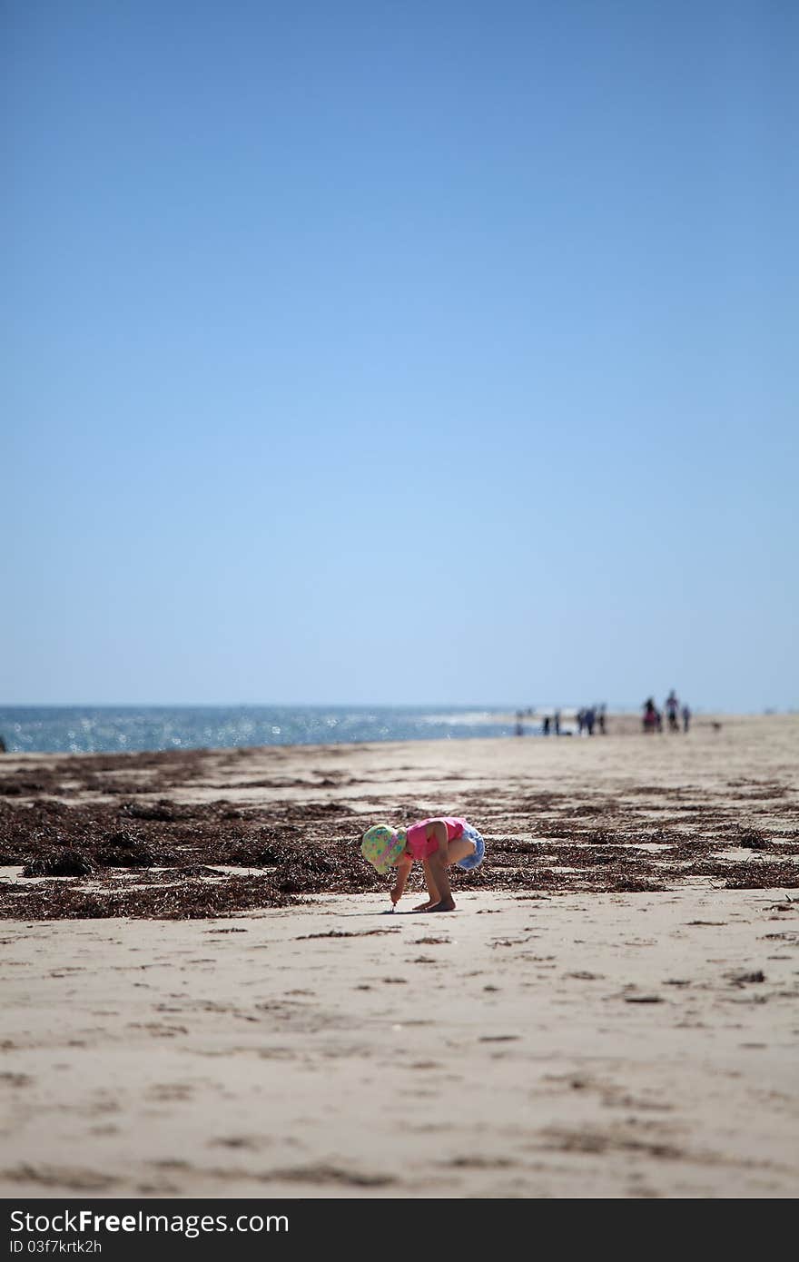 Toddler on beach - lots of negative space used to create the somber mood of this image. Toddler on beach - lots of negative space used to create the somber mood of this image