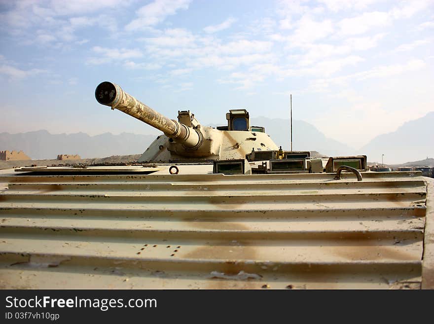 A cannon of BMP-1 over cloudy sky and mountain background