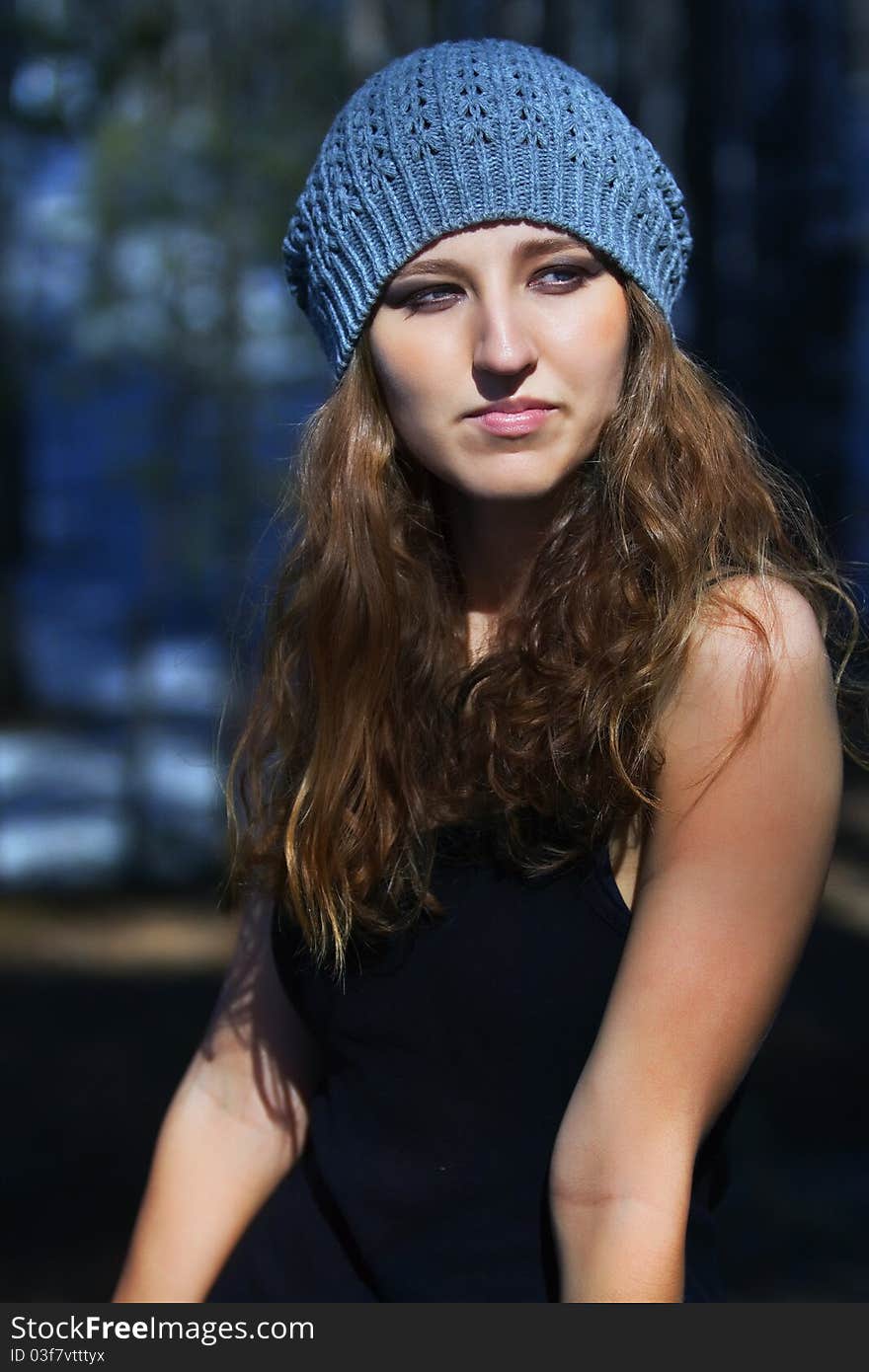 Beautiful smiling girl in a blue beret in park