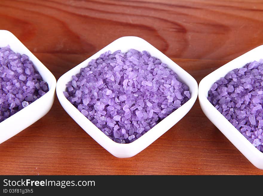 Lavender spa salt in white bowls on a wooden background