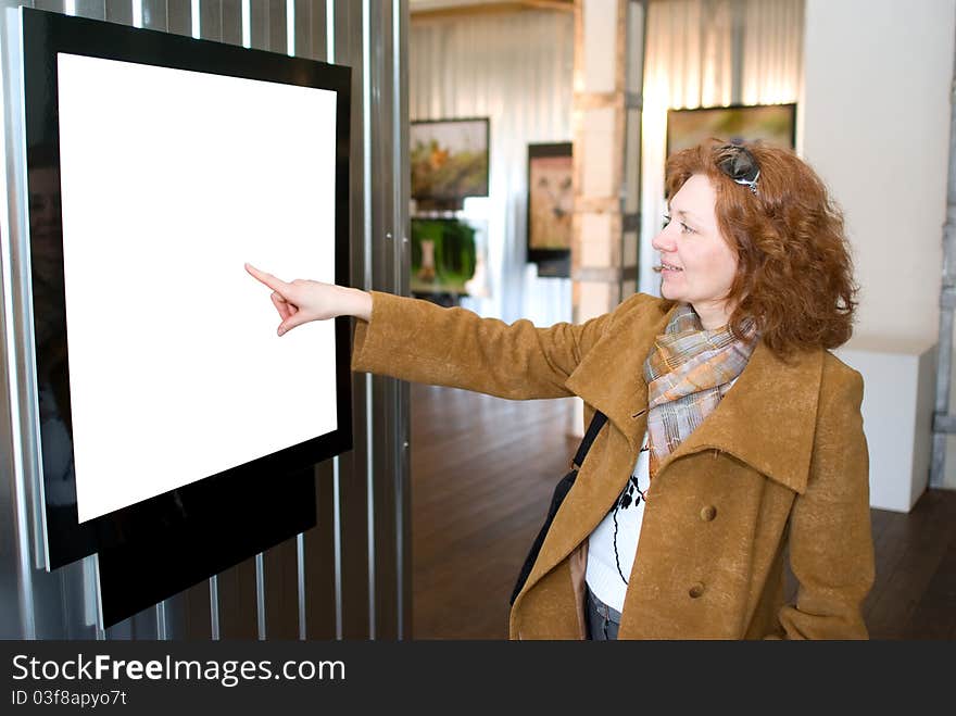 The redhead woman points to a picture