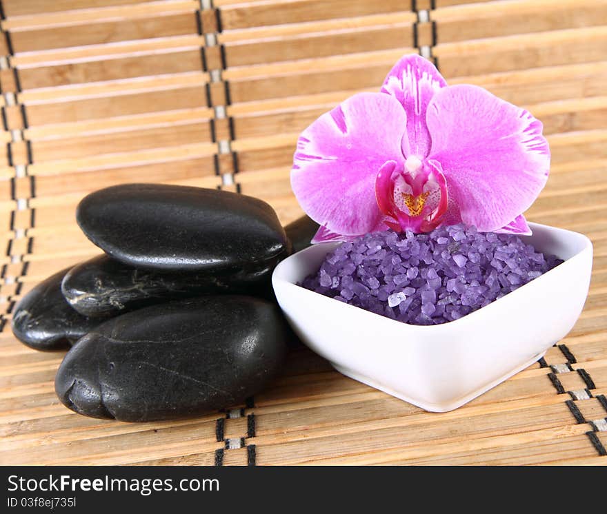 Lavender spa salt, spa stones and an orchid flower. Lavender spa salt, spa stones and an orchid flower