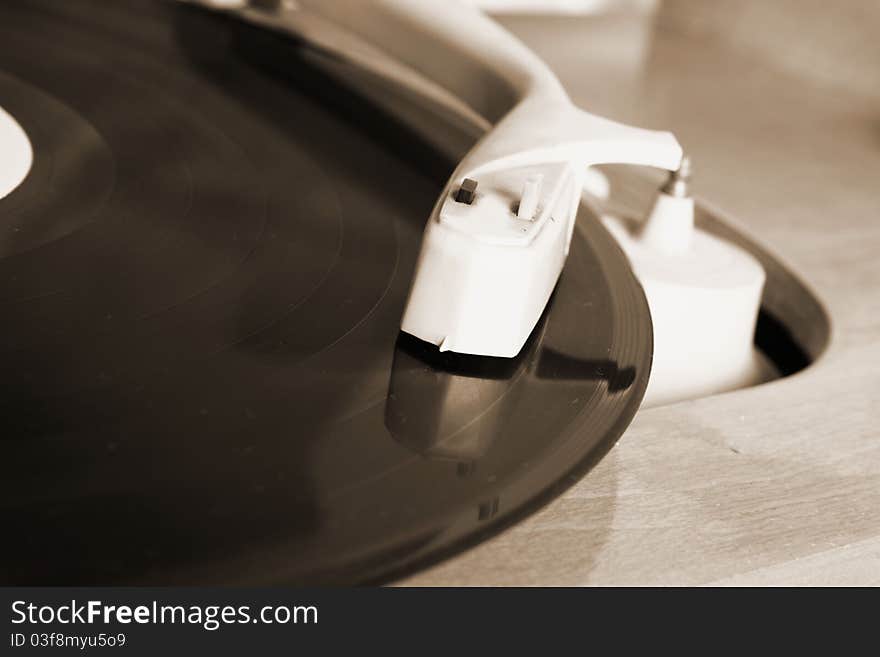 Turntable and vinyl record in close up in sepia