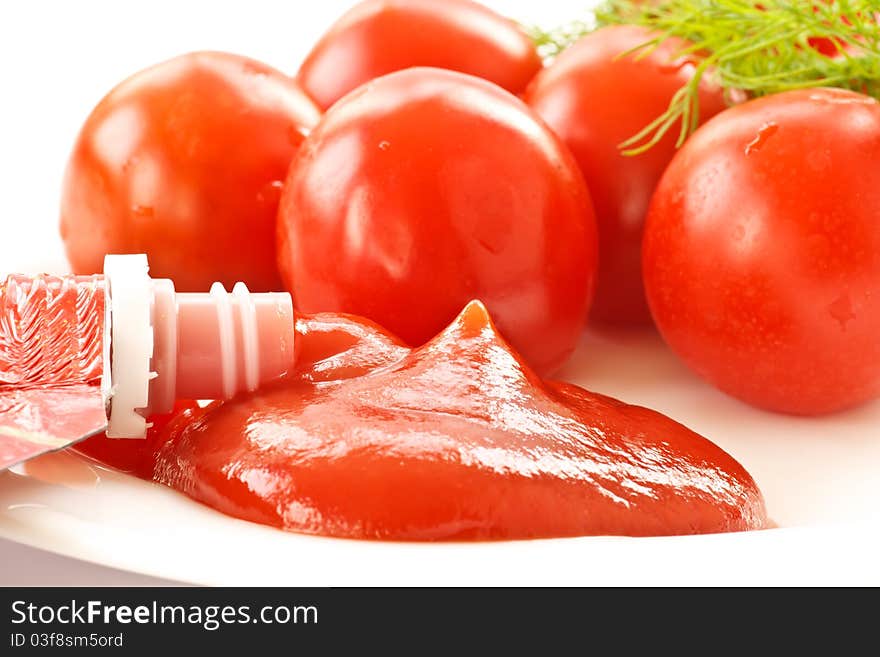 Fresh tomato ketchup on a background of ripe tomato