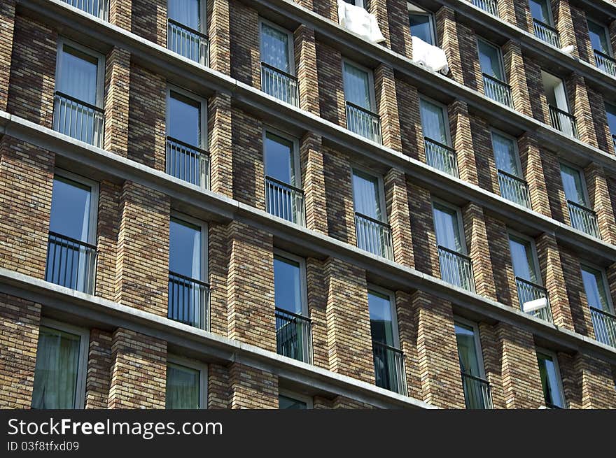 Fragment of the facade of the modern brick residential house with the same balcony. Detail.