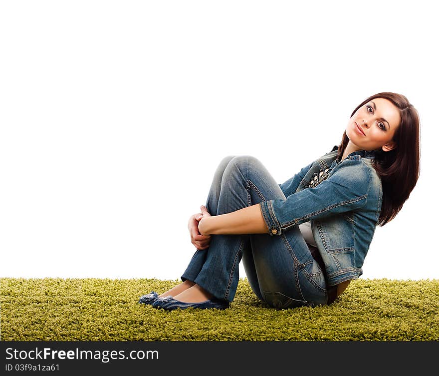 Brunette girl sitting on a green carpet