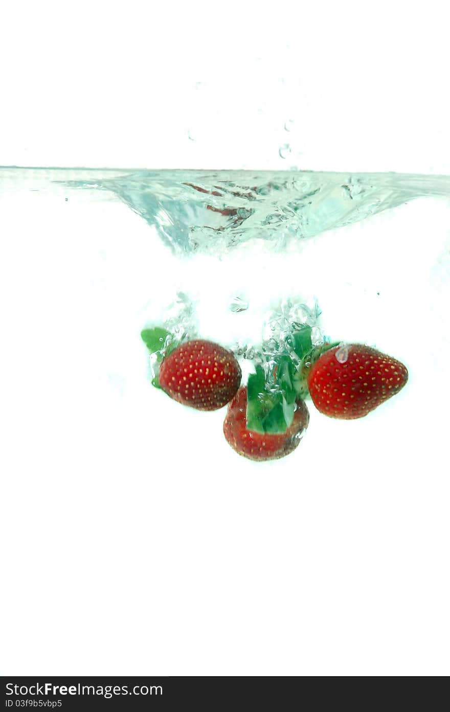 Strawberries splash into water isolated on white background