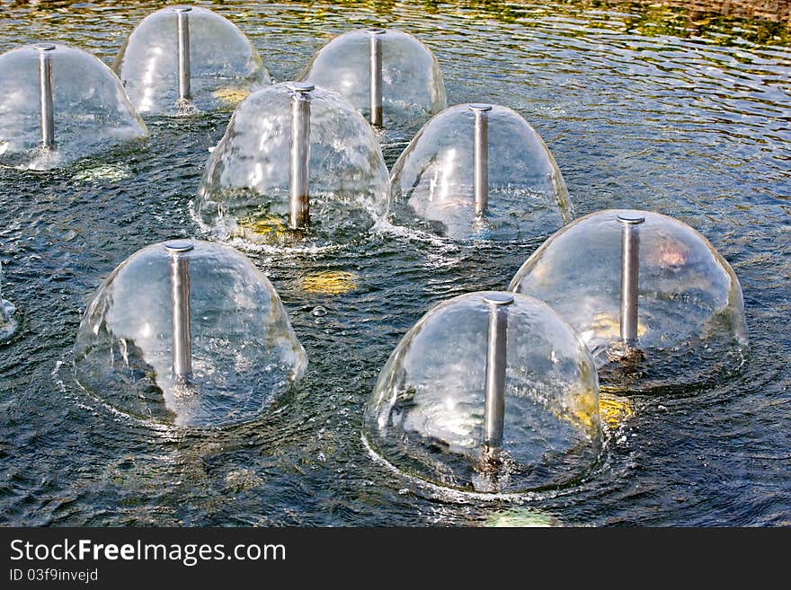 A group of small sperical fountains on a water in a sunny day. A group of small sperical fountains on a water in a sunny day