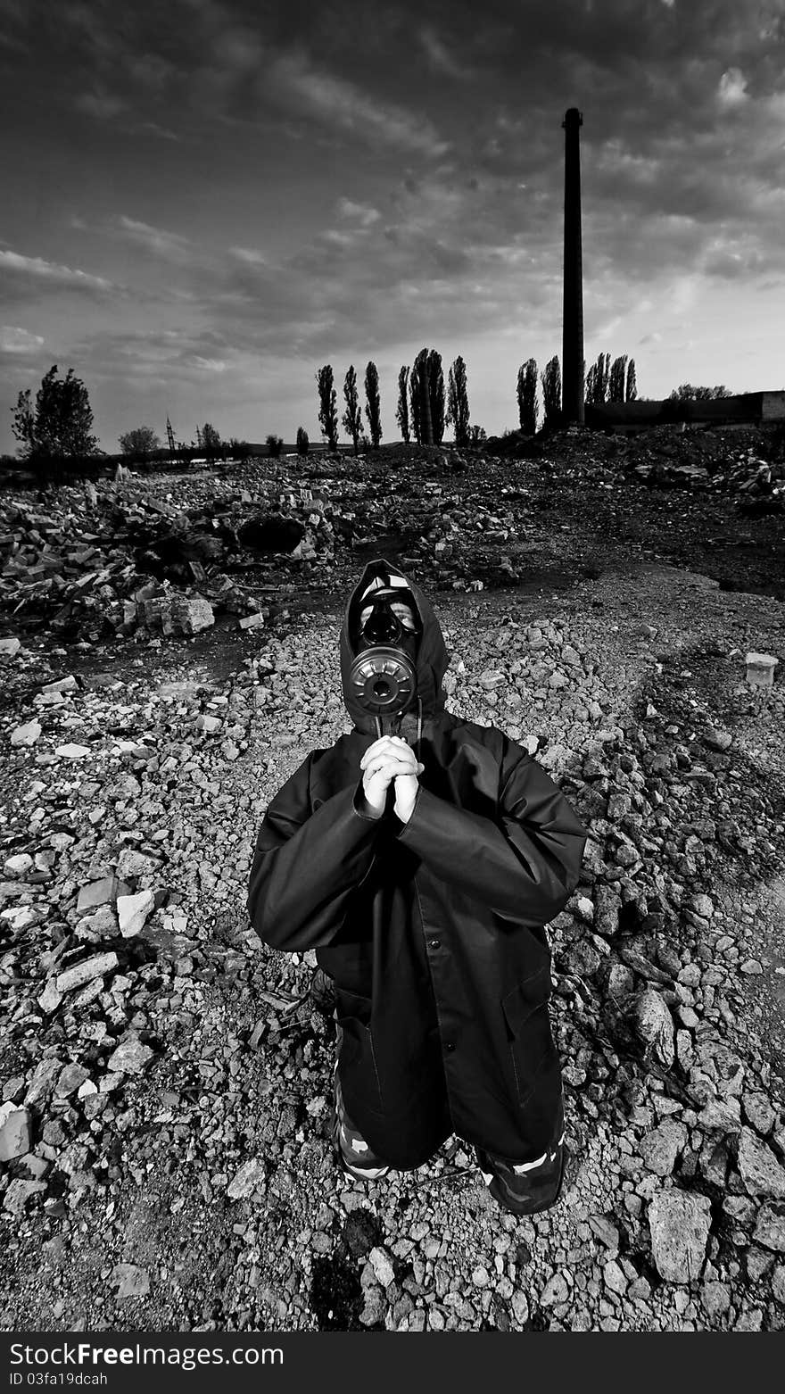 Scientist with gas mask praying in destroyed territory after explosion. Scientist with gas mask praying in destroyed territory after explosion