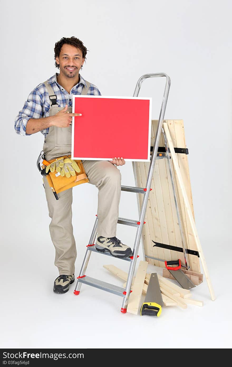 Smiling laborer with ladder and red panel