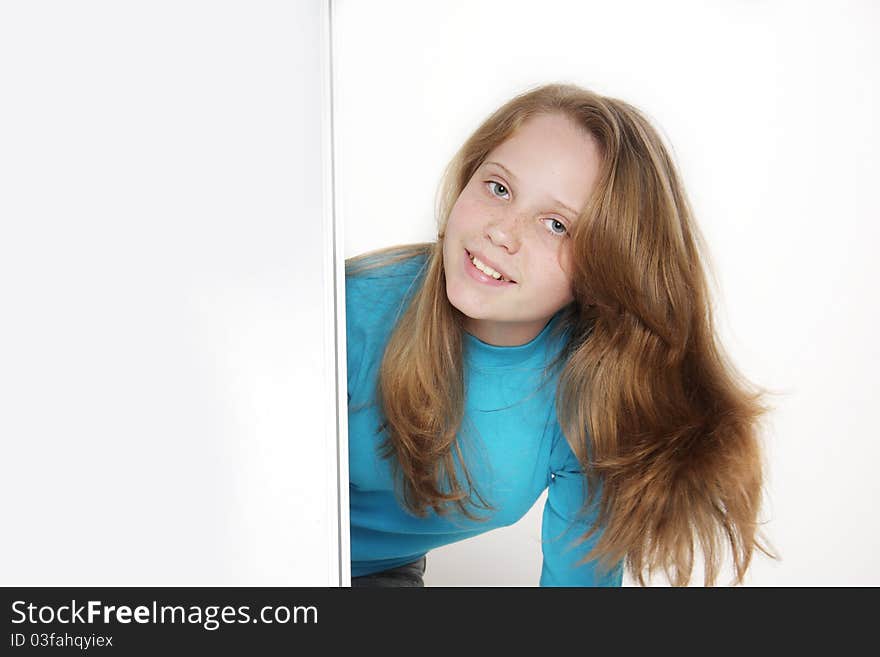 Cute teen girl looking out from white board