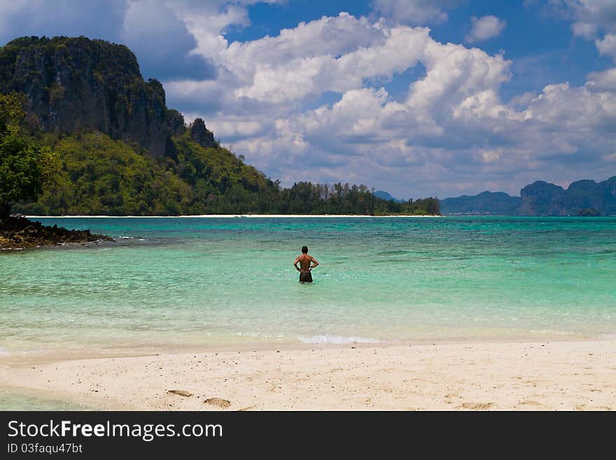 Man walking in water of exotic beach in Krabi Thailand Asia. Man walking in water of exotic beach in Krabi Thailand Asia