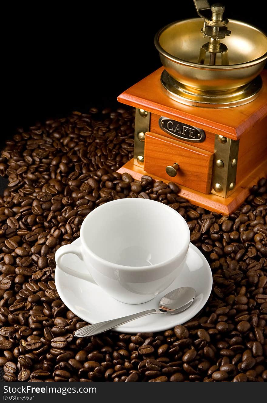 Cup of coffee and grinder on beans