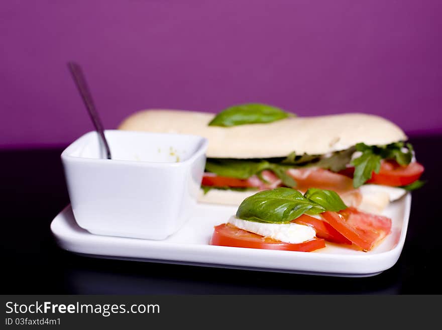 Long baguette sandwich with ham,  fresh vegetables and pesto. Long baguette sandwich with ham,  fresh vegetables and pesto