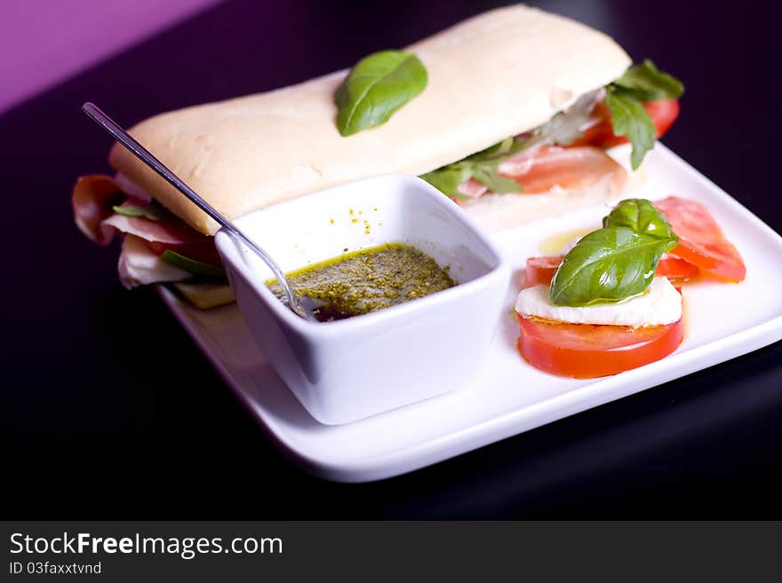 Long baguette sandwich with ham, fresh vegetables and pesto. Long baguette sandwich with ham, fresh vegetables and pesto