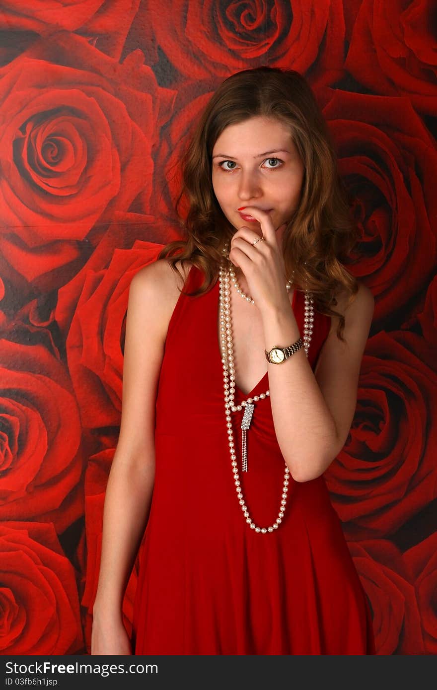 Girl in red dress posing at wall with red wallpaper. Girl in red dress posing at wall with red wallpaper.