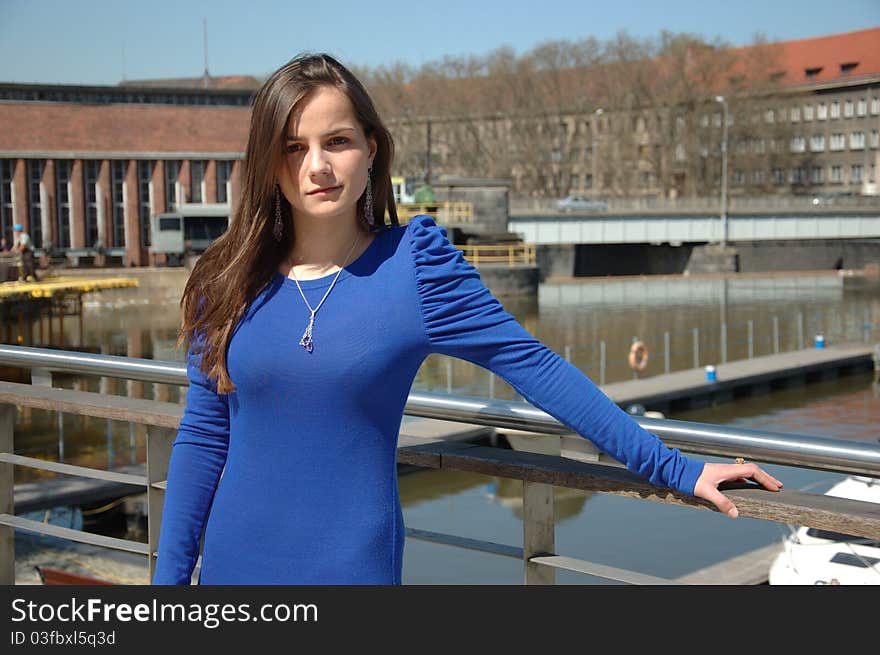 Sweet, young girl portrait. Teenage model in Poland wearing casual dress, smiling gently. Portrait at river side with boats as background. Sweet, young girl portrait. Teenage model in Poland wearing casual dress, smiling gently. Portrait at river side with boats as background.