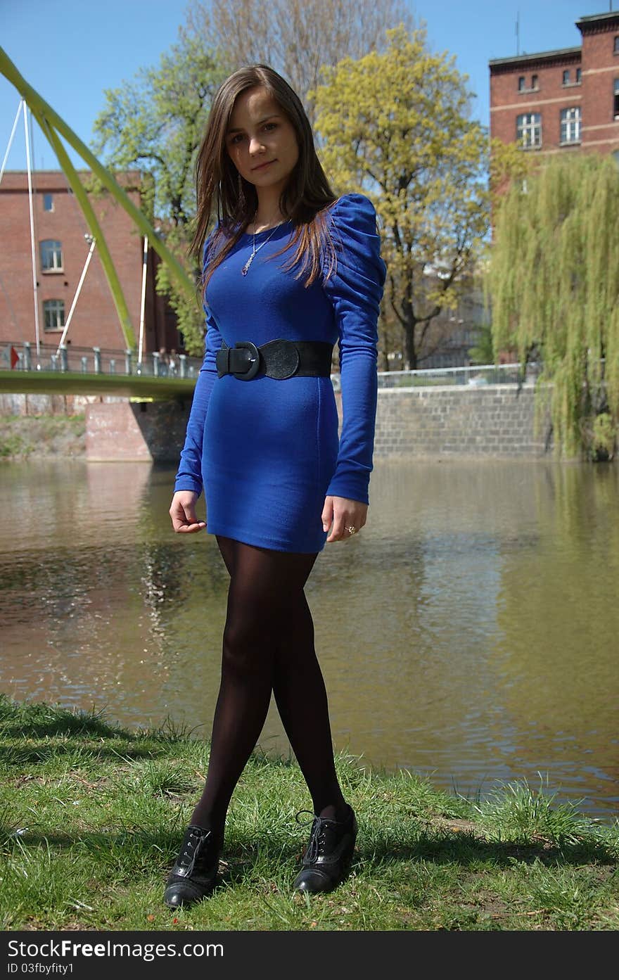 Sweet, young girl portrait. Teenage model in Poland wearing casual blue dress and black stockings, smiling gently. Sweet, young girl portrait. Teenage model in Poland wearing casual blue dress and black stockings, smiling gently.