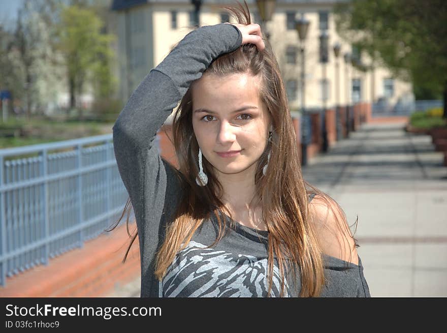 Close portrait of blonde teenager. Young girl, wearing casual clothes, holding her hairs up. Close portrait of blonde teenager. Young girl, wearing casual clothes, holding her hairs up.