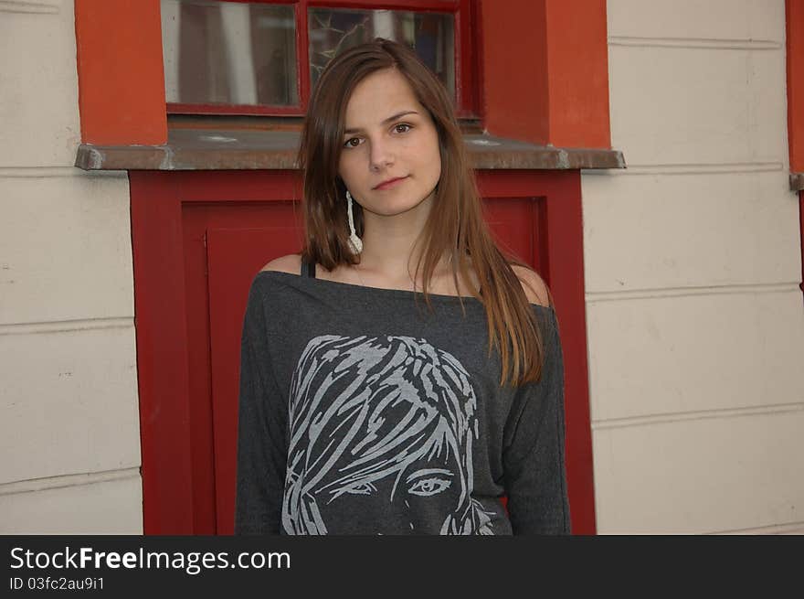 Teenage model in Poland. Young girl, kind face expression, blonde hairs, wearing casual clothes. Girl posing in the city with colorful tenement house as background. Teenage model in Poland. Young girl, kind face expression, blonde hairs, wearing casual clothes. Girl posing in the city with colorful tenement house as background.