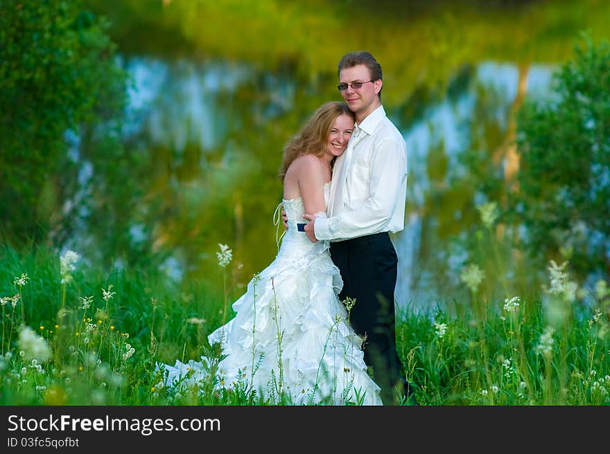 The bride and groom around the lake