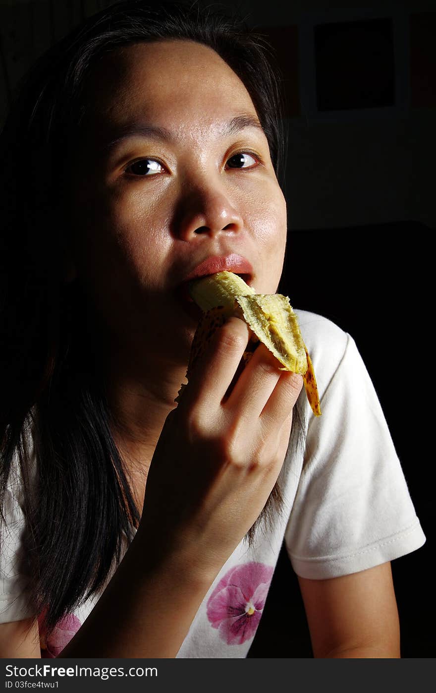 Young woman eating banana