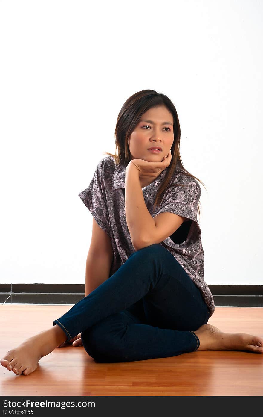 A beautiful young Asian woman siting on the floor