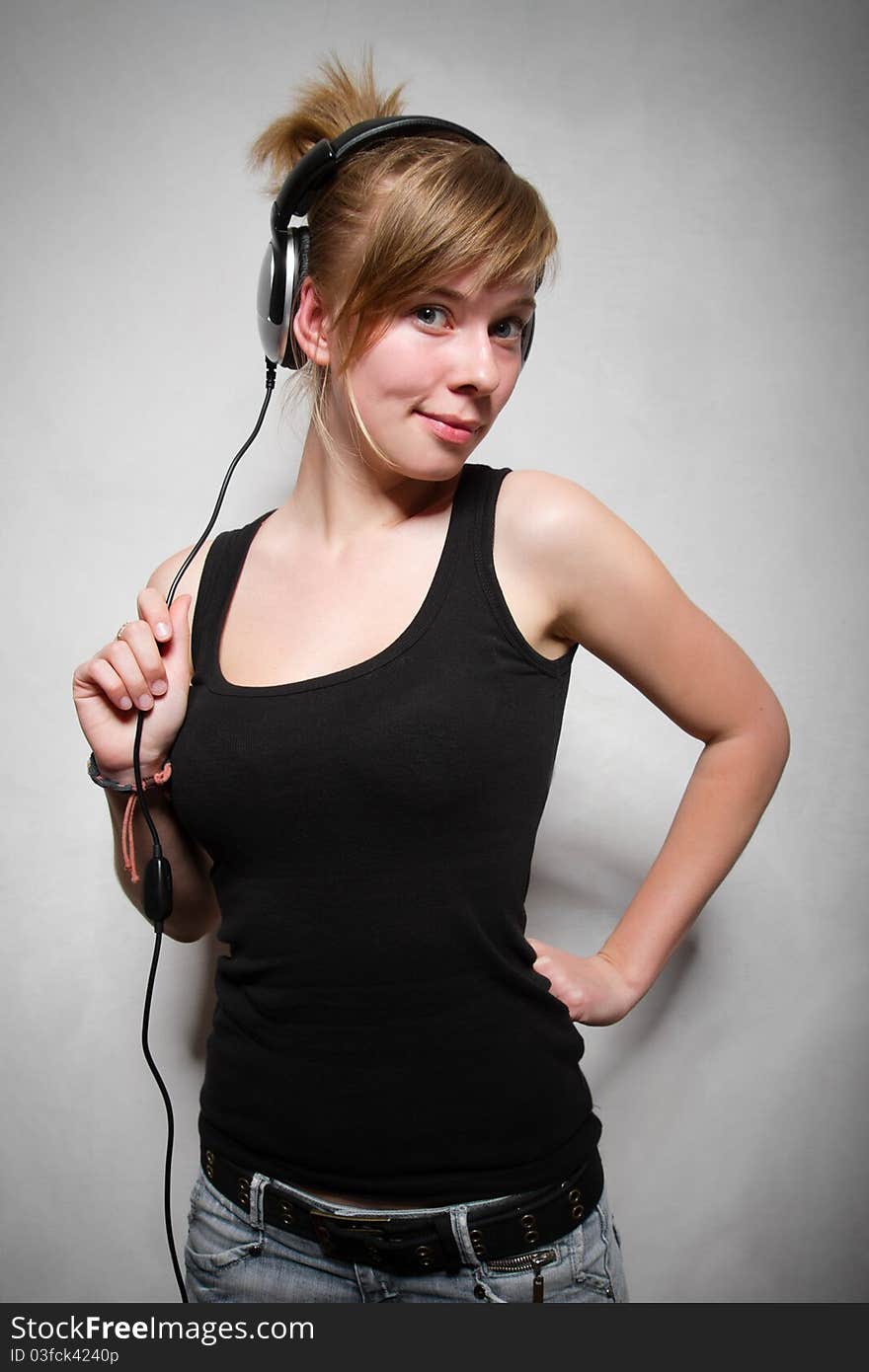 Late teen attractive chick posing with stereo headset on her head. Late teen attractive chick posing with stereo headset on her head