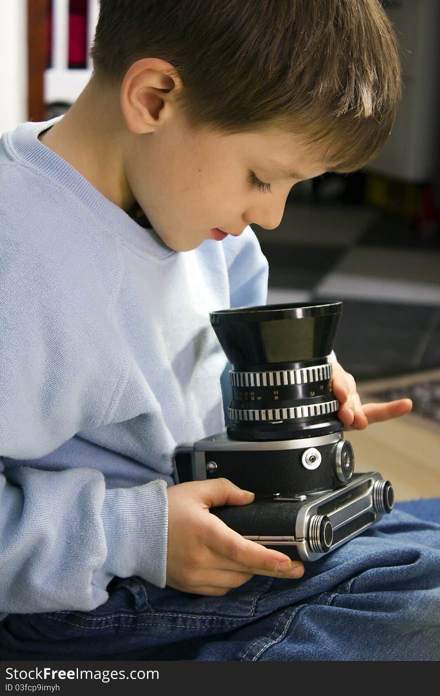 Young boy examining a vintage medium format camera. Young boy examining a vintage medium format camera