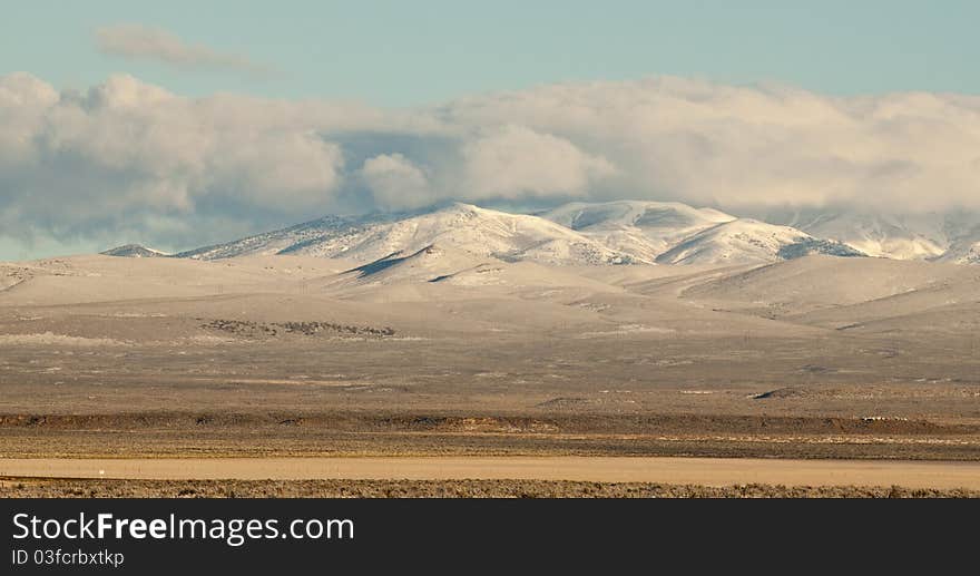 A peaceful cloud hovers above a nice snowy mountain. A peaceful cloud hovers above a nice snowy mountain.