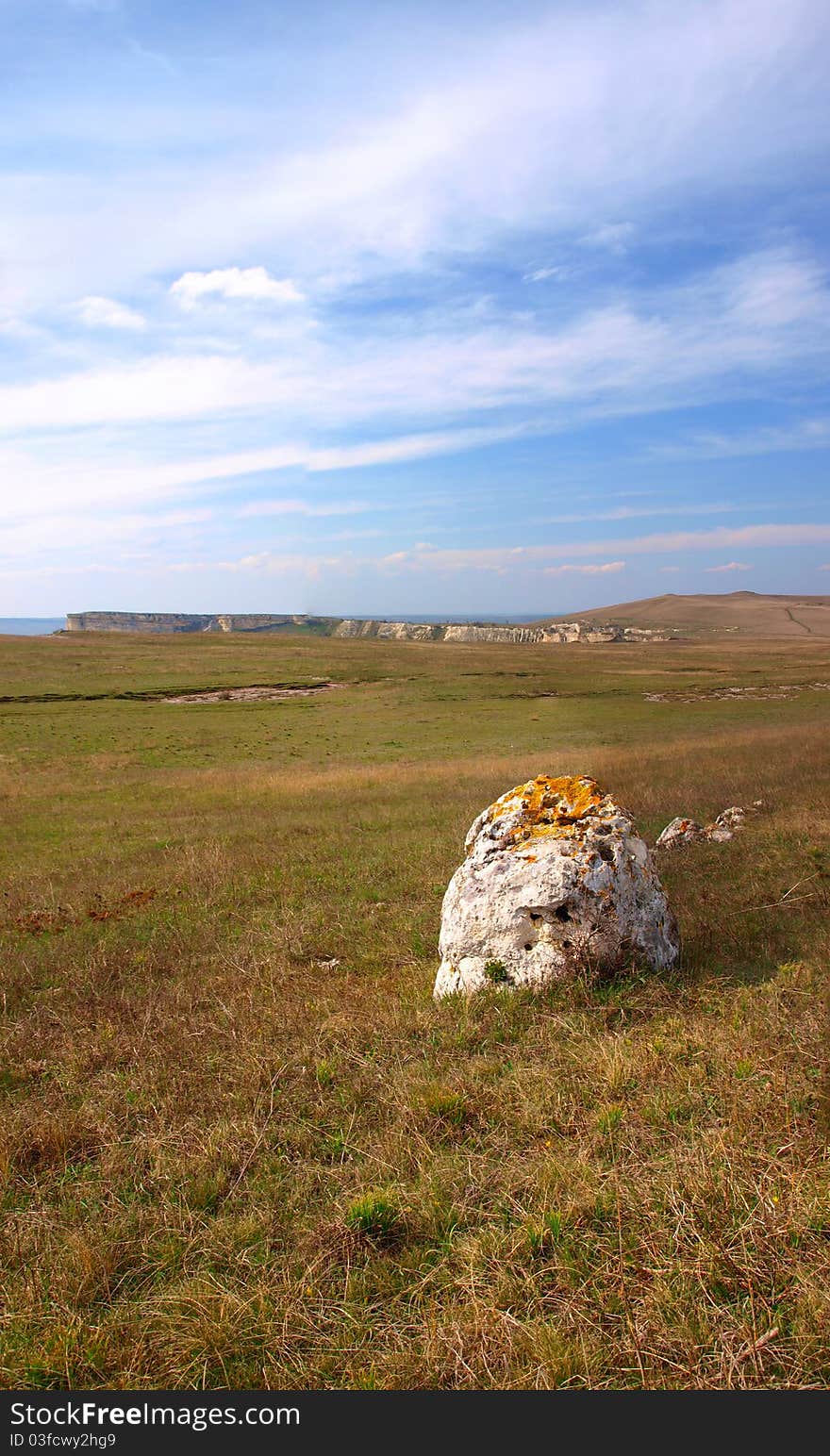 Vertical panorama of a blue sky and a stone