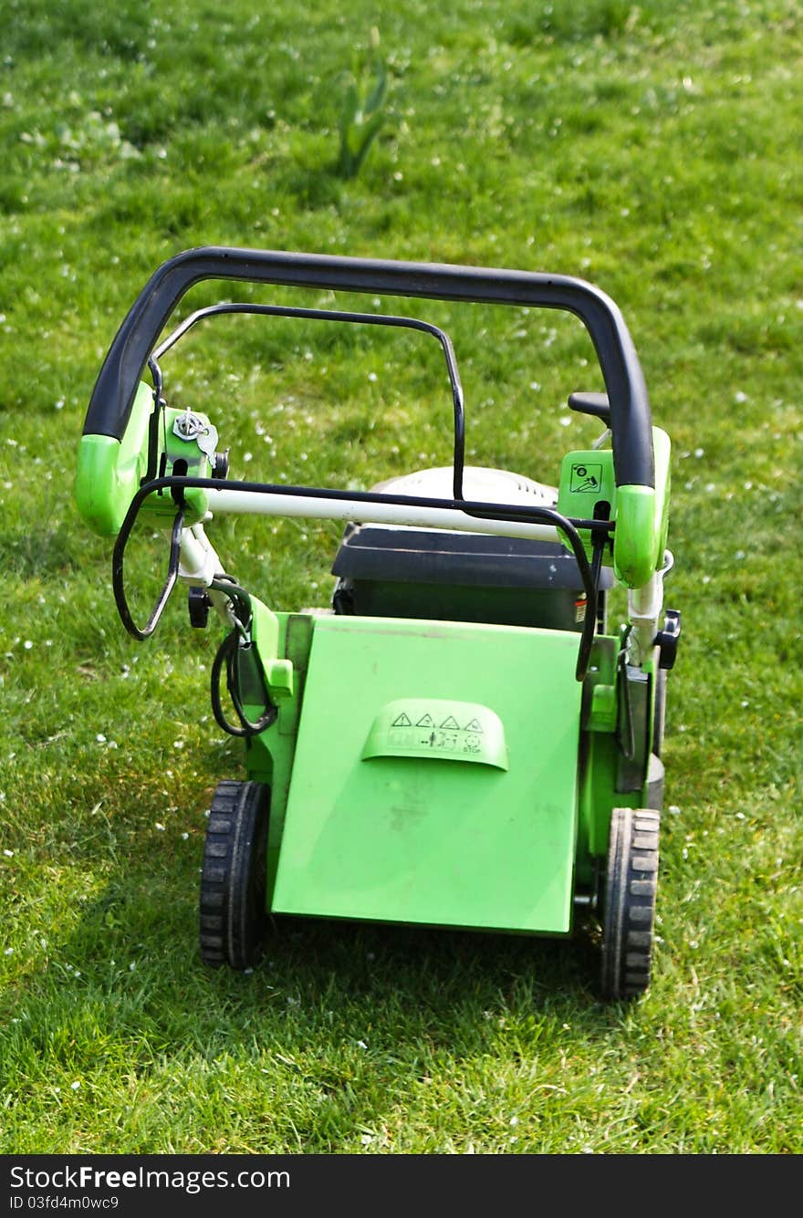 Lawn mower on fresh cut grass in the garden