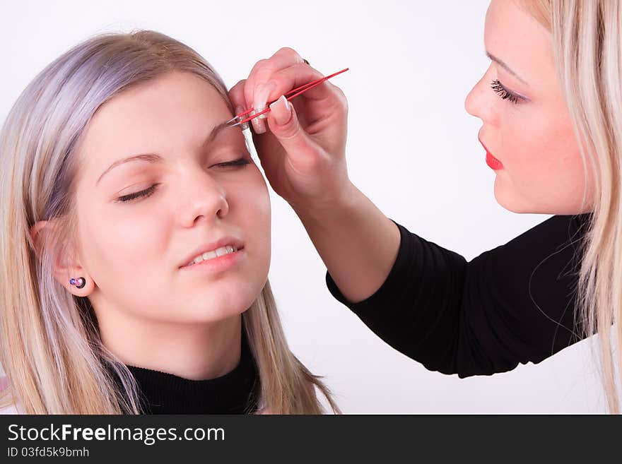 Stylist is applying eyebrow tweezers for young girl. Stylist is applying eyebrow tweezers for young girl