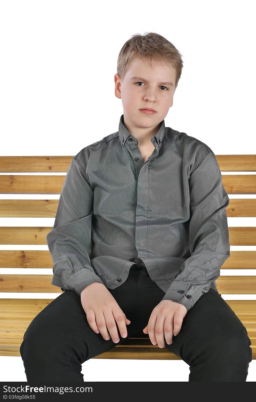 Serious Boy Sitting On A Bench