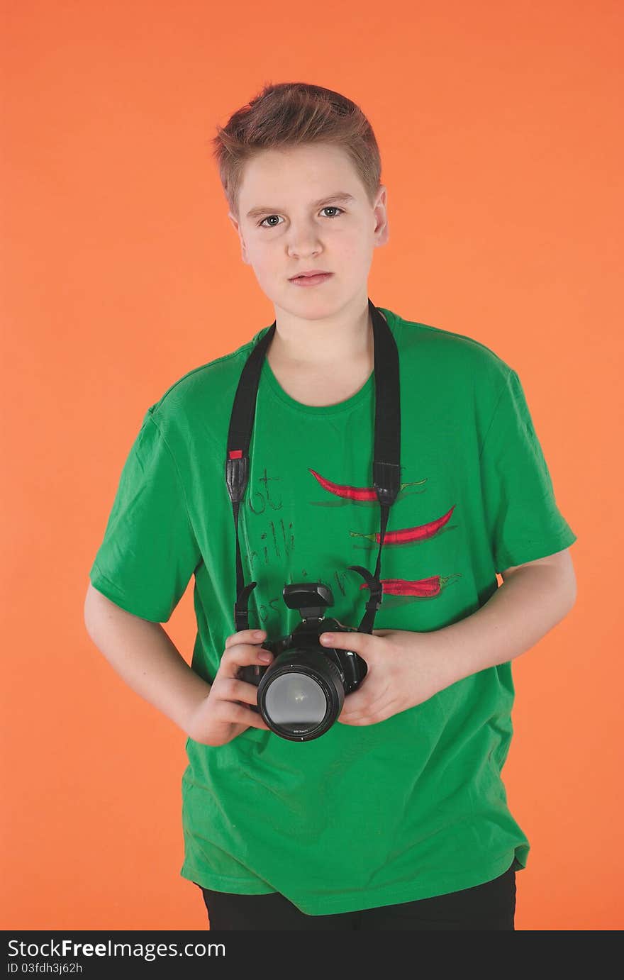 Boy with photocamera. Orange background