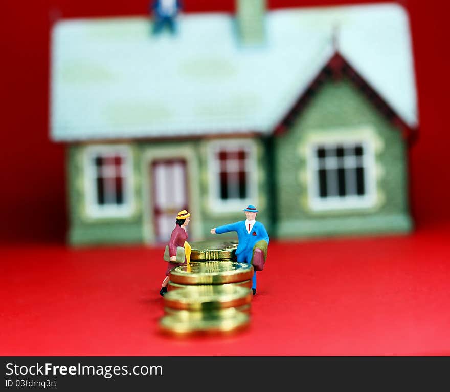 A couple on a staircase of gold coins in the front of a large house in the background on a slight angle with a light pastel red background, asking the question are you on a financial slippery slope.