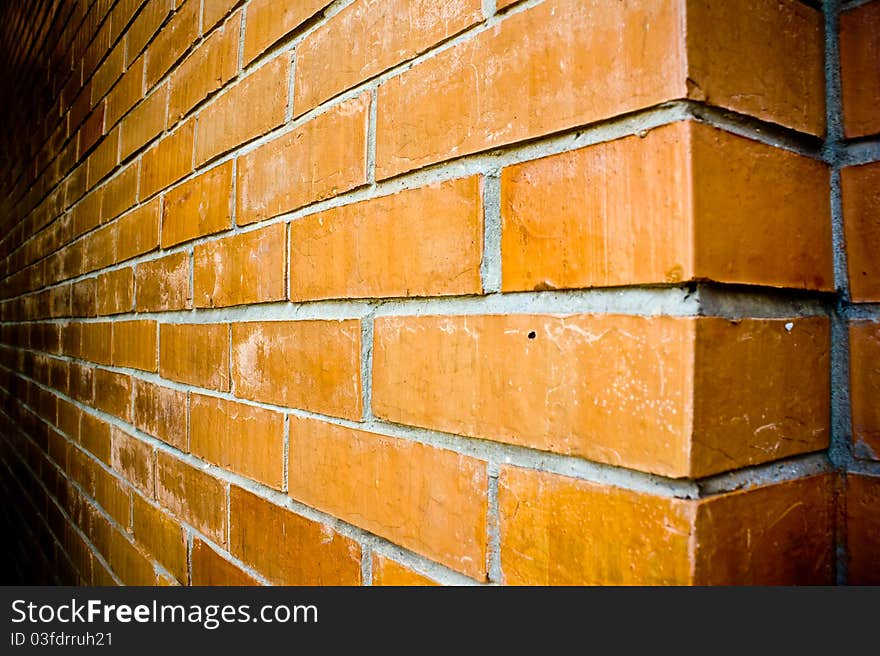 Perspective close-up details of an orange-brown brick wall.